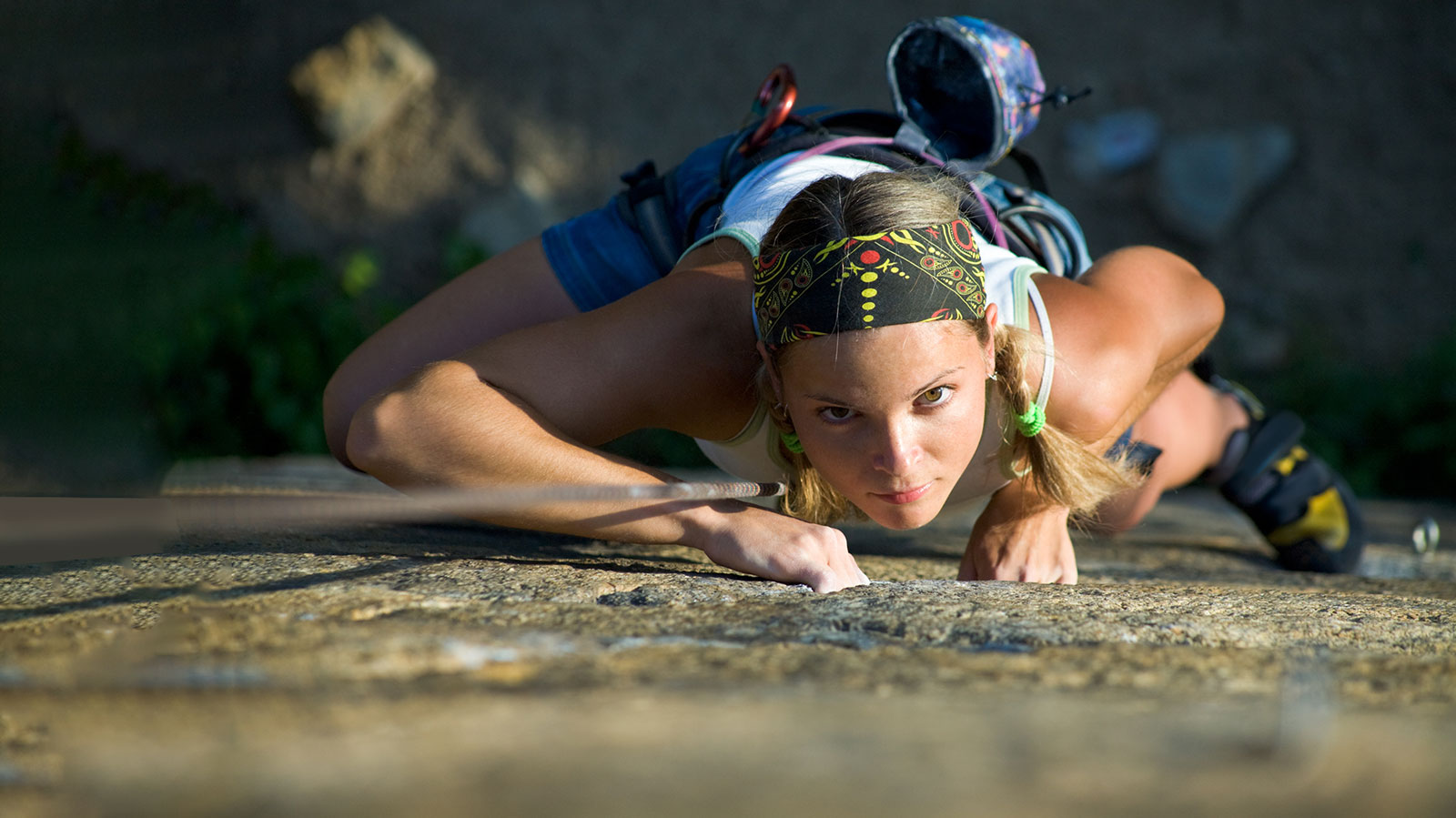 Woman rock climbing with intense look on her face