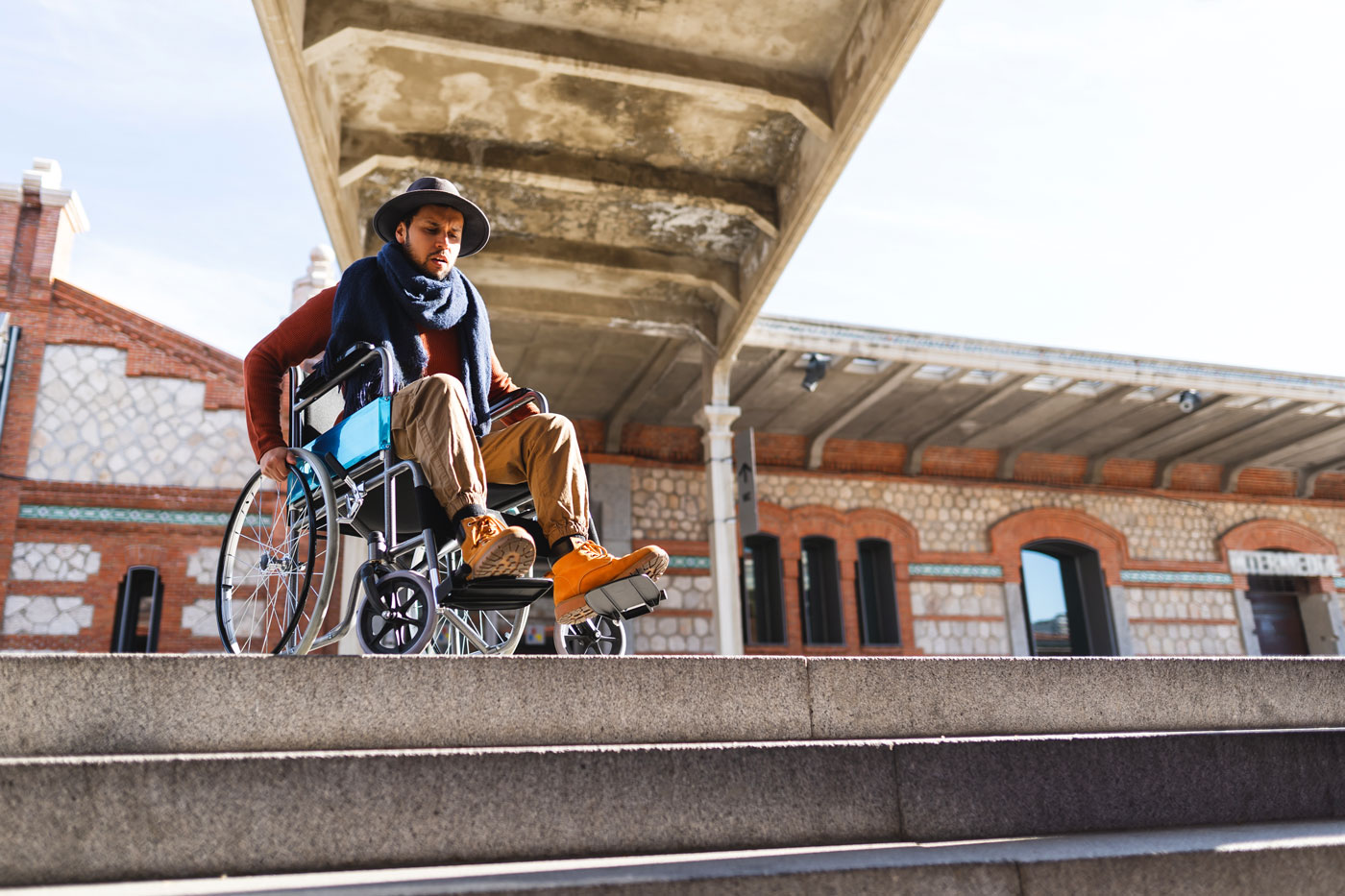 Accessibility makes a difference to this man in wheelchair at top of a set of stairs