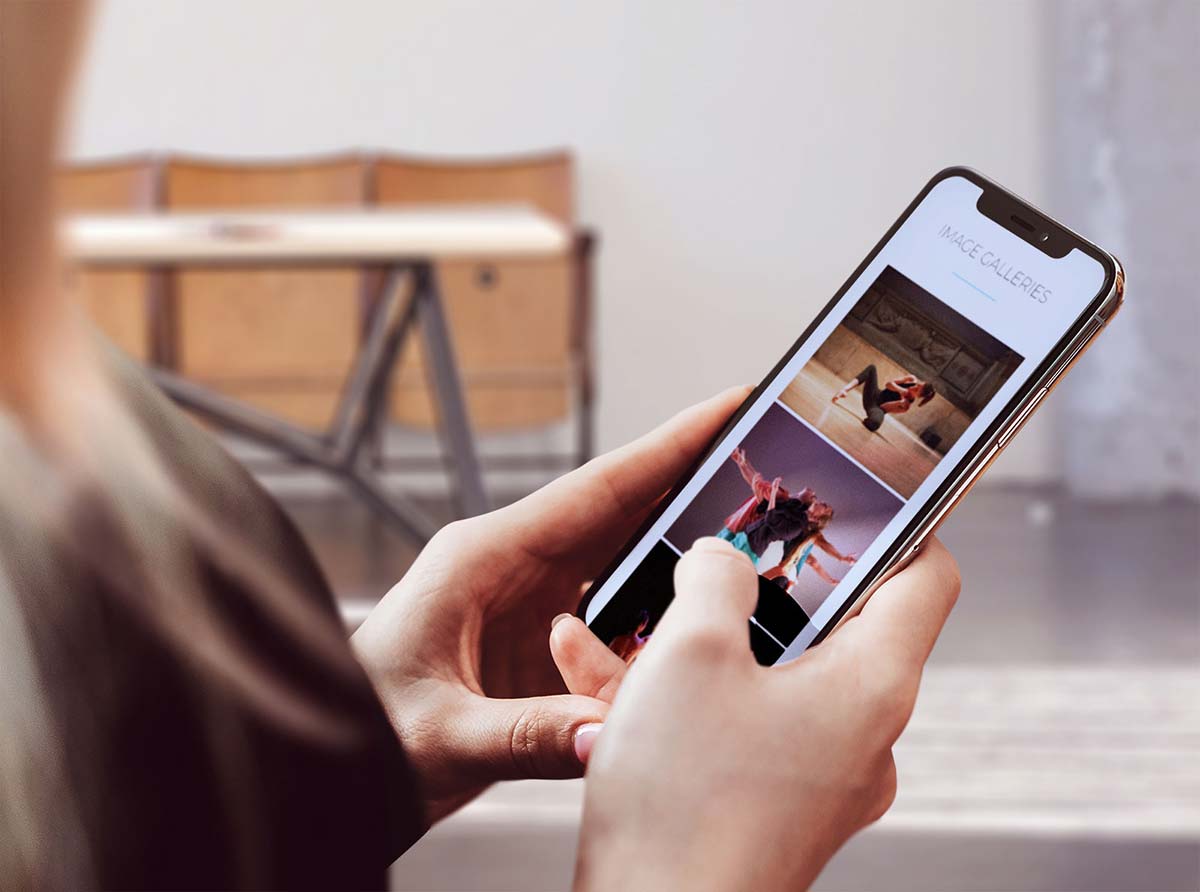 A person viewing a website on a mobile phone illustrating the importance of a mobile-ready or responsive website for technical SEO. 