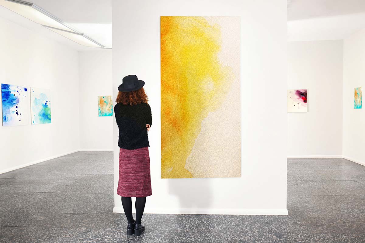 Woman admiring abstract artwork during an inspiration expedition for creativity in business.