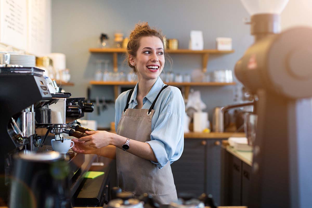 Barista crafting coffee in a community hub, representing creativity in business success.