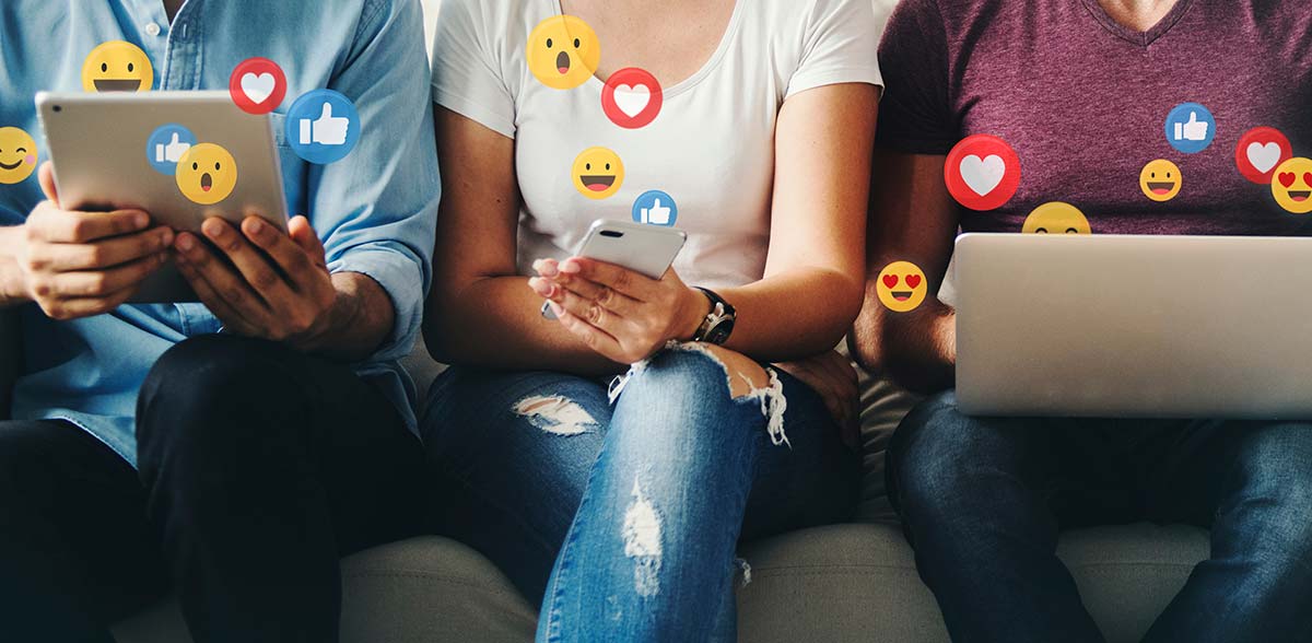 Three people using digital devices with social media reaction icons floating around them, representing engagement and interaction. A perfect visual for Quick Social Media Marketing Tips.