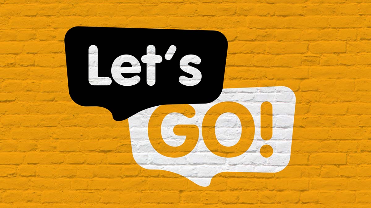 the words "Let's Go!" in speech bubble on a yellow/gold brick background 