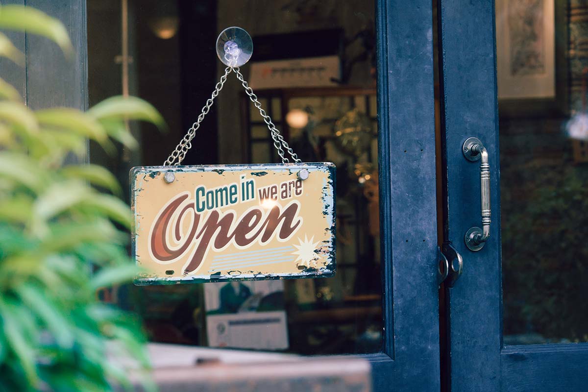 A vintage "Come in, we are open" sign, symbolizing the welcoming aspect of small business marketing strategies.