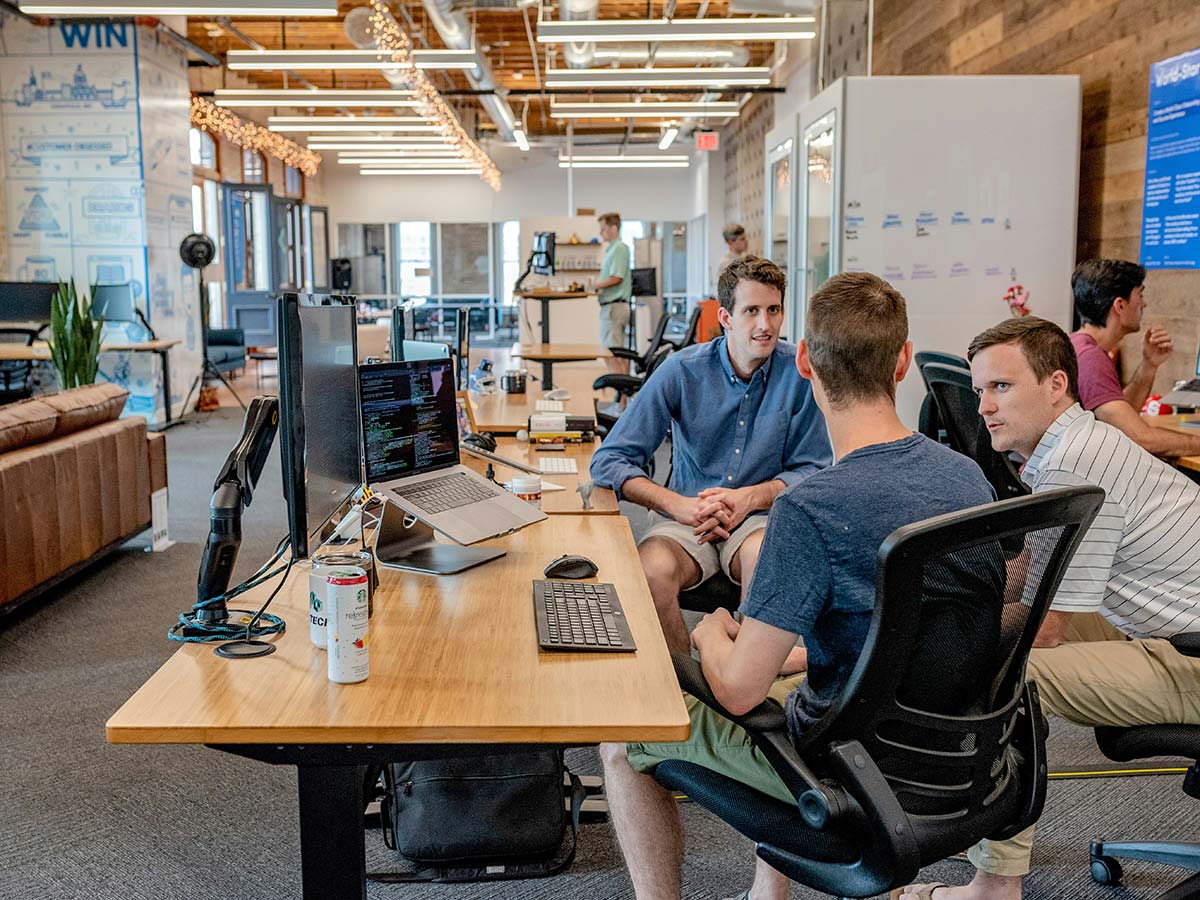 Creative team collaborating at desk with computers, custom WordPress web design in Western Massachusetts workspace