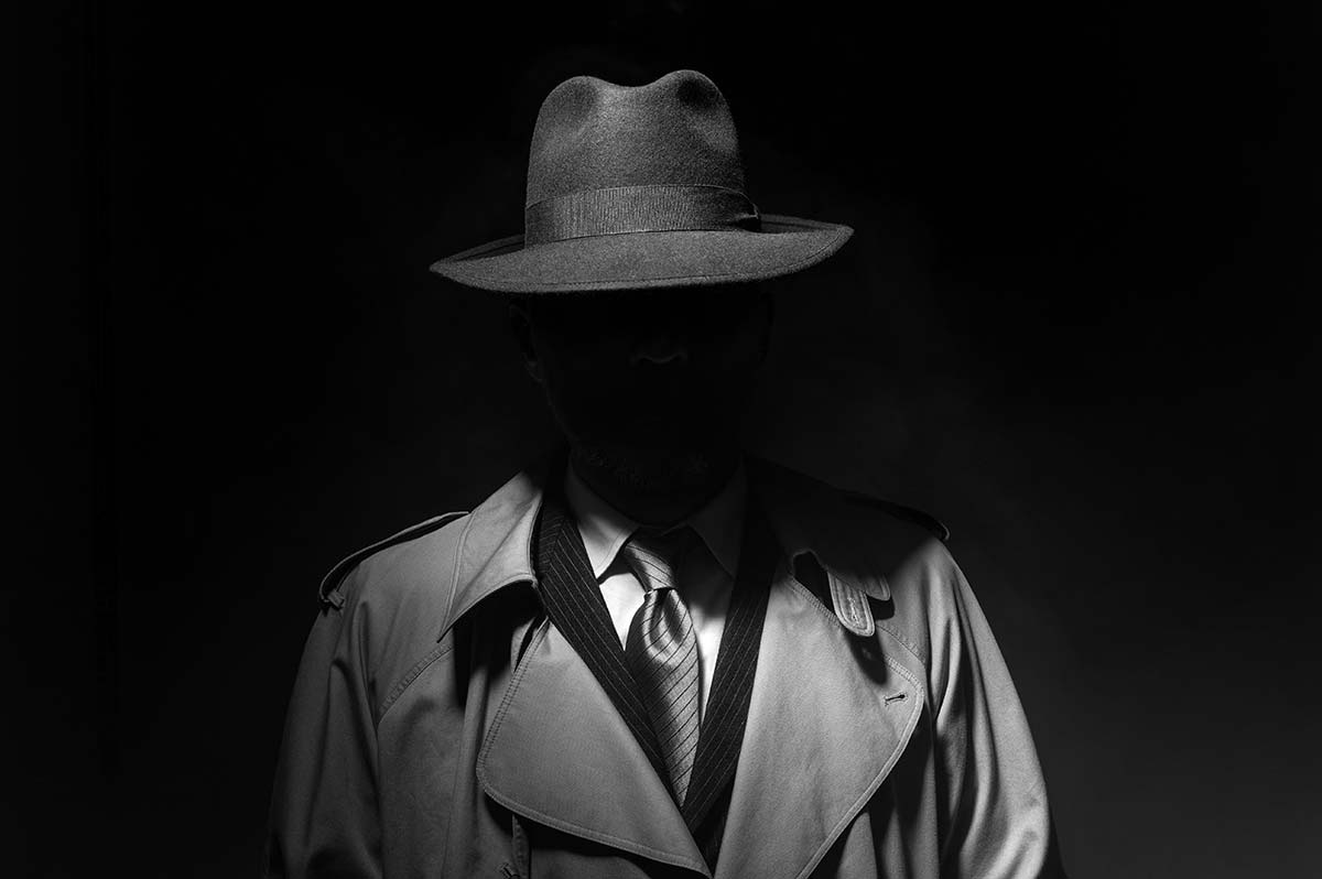Shadowy detective in trench coat and hat, representing uncovering hidden SEO strategies used by competitors