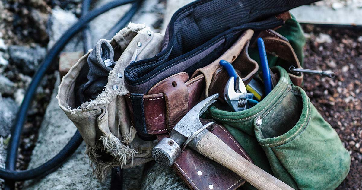 Tool belt with essential construction tools including hammer and pliers, representing skilled trades and home services