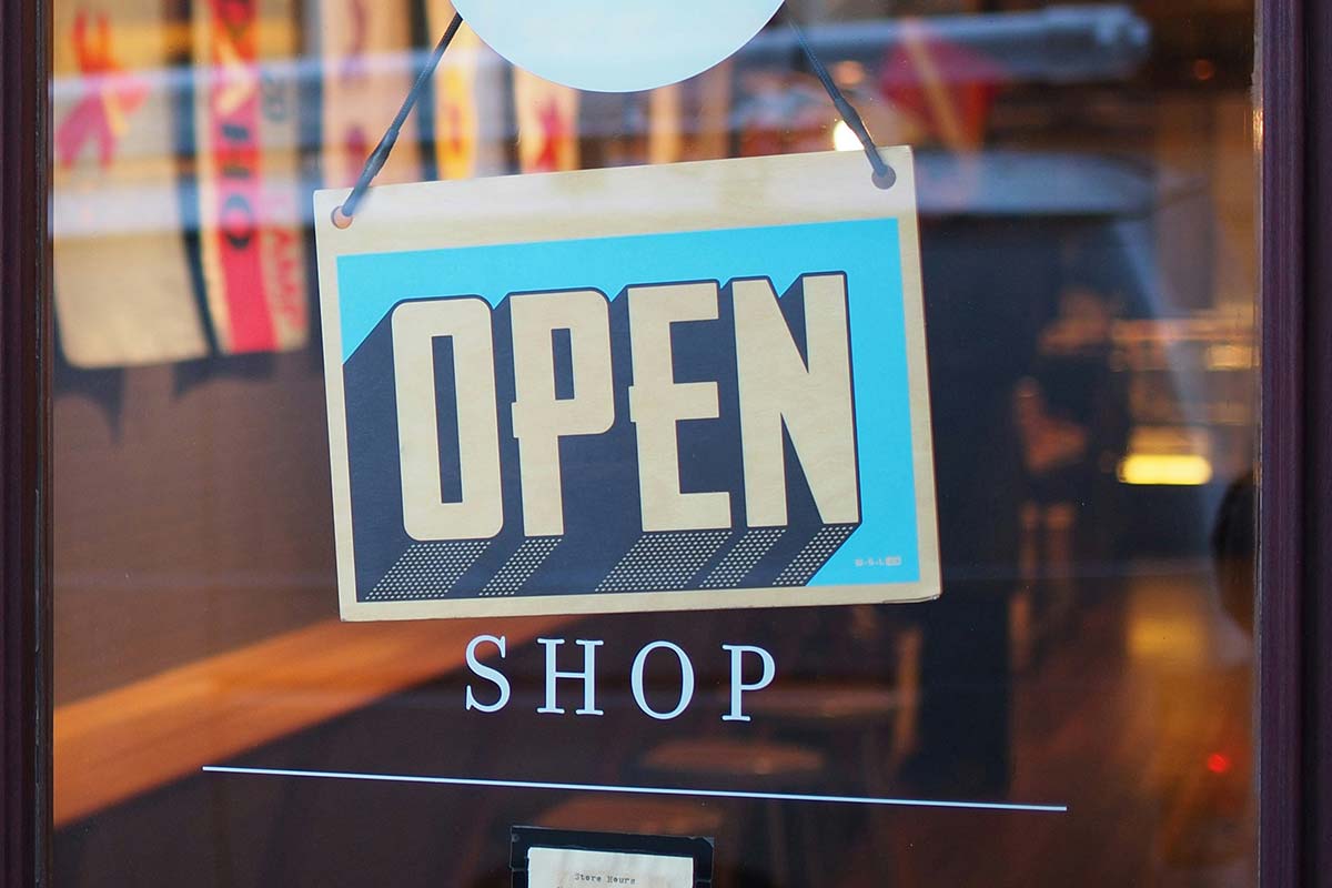 “Open” shop sign on a storefront door, representing local business visibility and readiness to serve customers