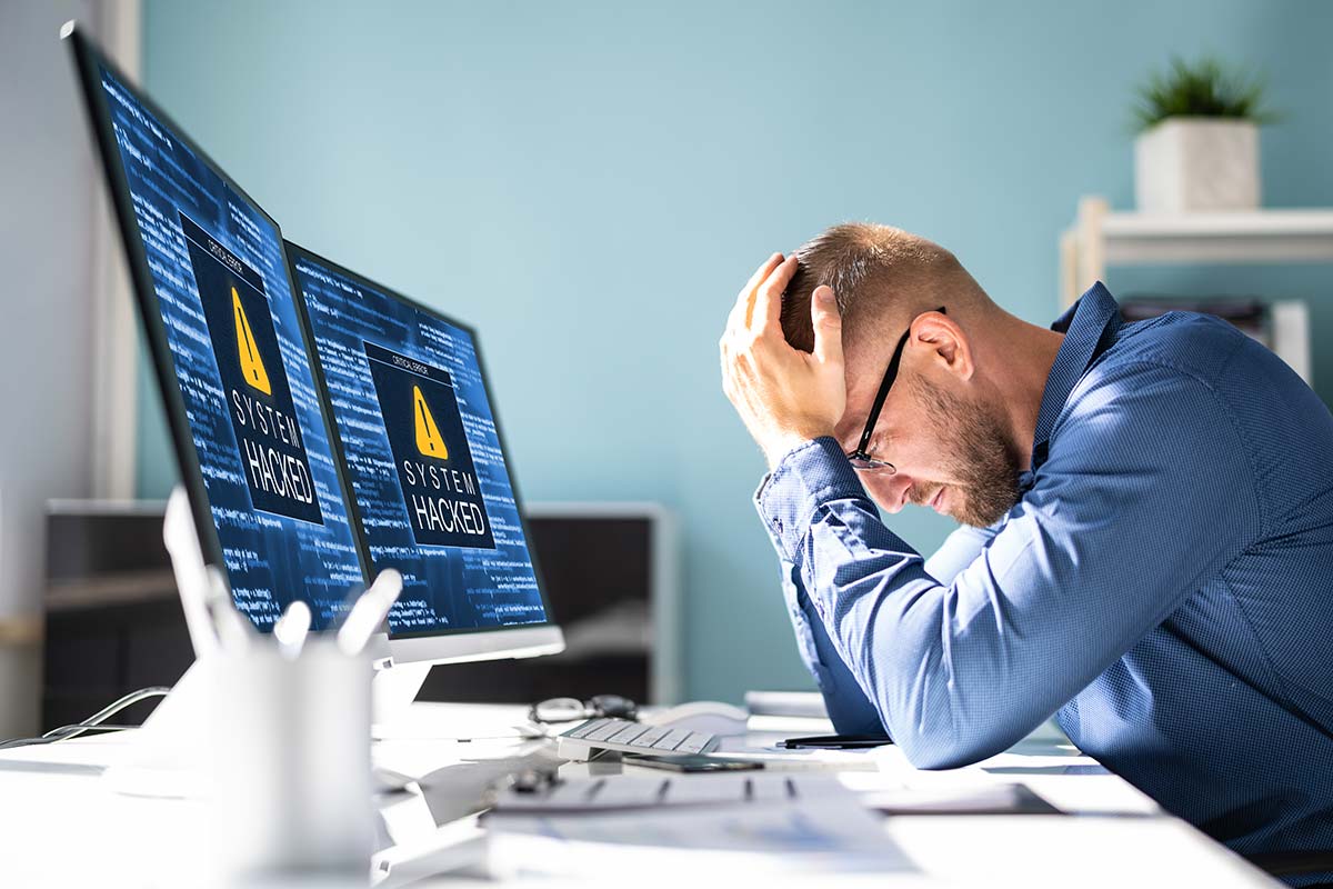 Business owner reacting to a hacked WordPress website with security warnings on screen