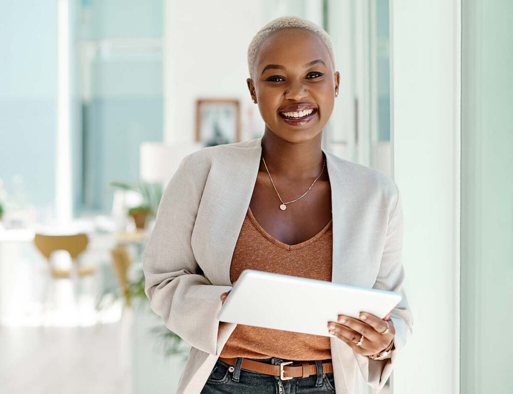 Nonprofit leader holding a tablet in a bright contemporary office.