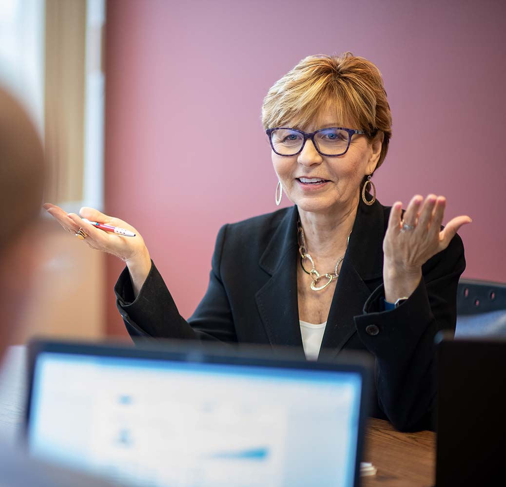 Financial Advisor Pat Grenier at her desk working with a client.